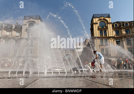 La gente a giocare in Karlsplatz Stachus Fontana, Monaco di Baviera Germania Foto Stock