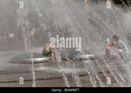 La gente a giocare in Karlsplatz Stachus Fontana, Monaco di Baviera Germania Foto Stock