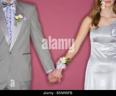 Matura in abbigliamento prom tenendo le mani Foto Stock