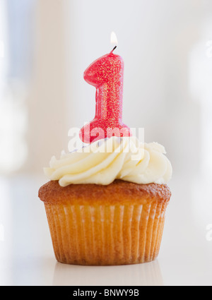 Candela accesa sul cupcake per la prima celebrazione di compleanno Foto Stock