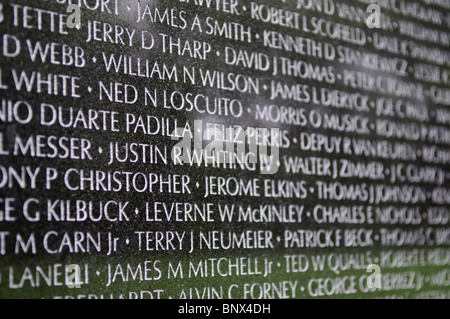 Il Vietnam Veterans Memorial nomina Washington DC // WASHINGTON DC - i visitatori osservano il Vietnam Veterans Memorial sul National Mall di Washington DC. Progettato da Maya Lin e dedicato nel 1982, il memoriale è costituito da due pareti di granito nero che mostrano i nomi di più di 58.000 americani morti o rimasti dispersi dalla guerra del Vietnam. La superficie lucida crea riflessi dei visitatori, mentre vedono i nomi disposti cronologicamente sul monumento commemorativo a forma di V. Foto Stock