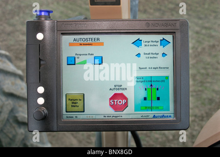 Un conducente del trattore con la navigazione GPS per campo accurata cernita. Foto Stock