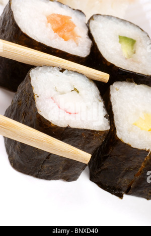 Close-up di sushi in un vassoio bianco e bacchette di legno. Messa a fuoco selettiva. Con copia spazio. Foto Stock