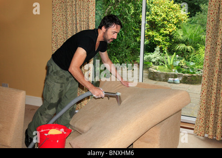 Professional detergente per la pulizia a vapore cuscini divano nel soggiorno di casa. Foto Stock