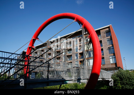 Guardando attraverso Hertford Union Canal passerella per l'Omega funziona appartamenti sull'Isola di pesce, Hackney Wick, London, Regno Unito Foto Stock