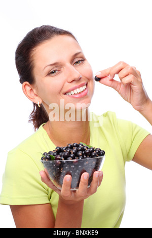 Sorridente giovane donna con ciotola piena di ribes nero nelle sue mani. Foto Stock