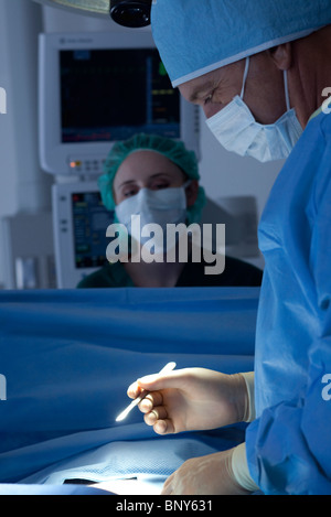 Chirurgo con un bisturi in mano la preparazione per iniziare la chirurgia Foto Stock