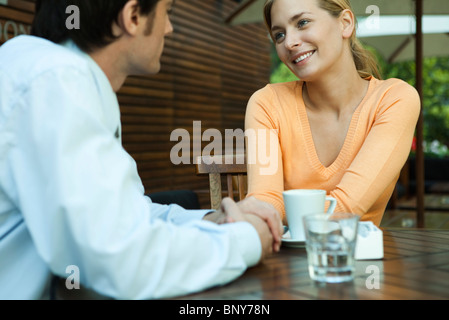 Giovane holding hands in outdoor cafe Foto Stock