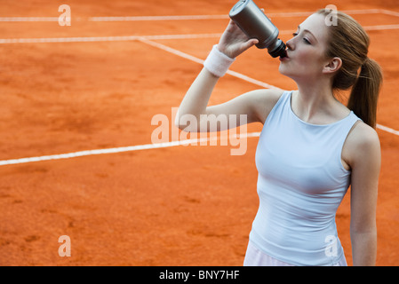 Giocatore di Tennis di bere dalla bottiglia di acqua Foto Stock
