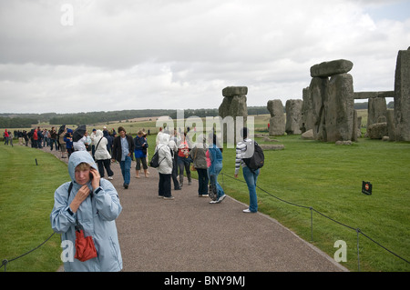 I turisti a piedi attorno a Stonehenge antico monumento, Wiltshire, Regno Unito Foto Stock