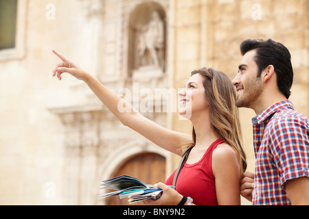 Sorridente giovane donna sottolineando attrazioni Foto Stock