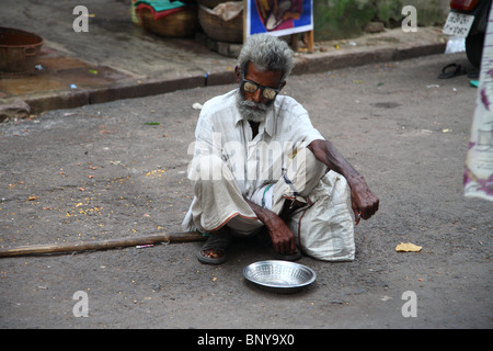 Un mendicante cieco squatting con il suo vaso in una strada in Kolkata (formerly Calcutta), India. Foto Stock