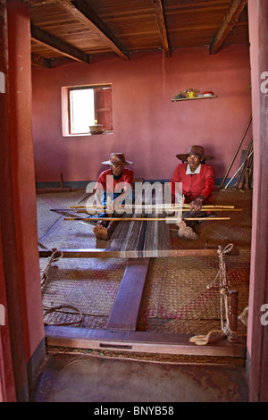 Due donne di seta tessitura stoffa su un telaio in una fabbrica di seta in Ambalavao nel sud-est del Madagascar Foto Stock