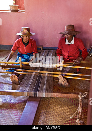 Due donne di seta tessitura stoffa su un telaio in una fabbrica di seta in Ambalavao nel sud-est del Madagascar Foto Stock
