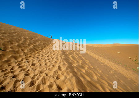 I turisti a piedi nelle dune di sabbia a Sossusvlei nel Naukluft Park Central Namib Desert Namibia Foto Stock