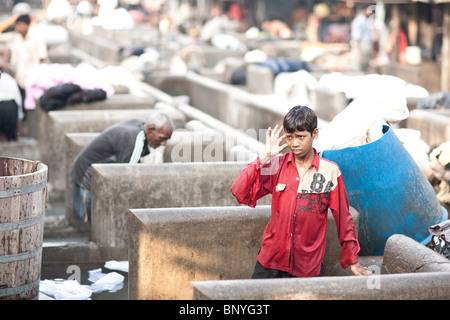 Un giovane Dhobi all opera al Dhobi Ghat, in Mumbai in India. Foto Stock