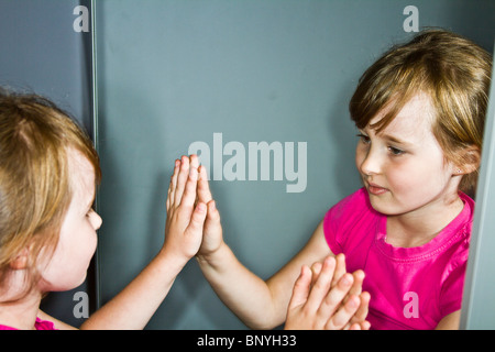 Ragazza giovane guardando in uno specchio in una dressing room Foto Stock