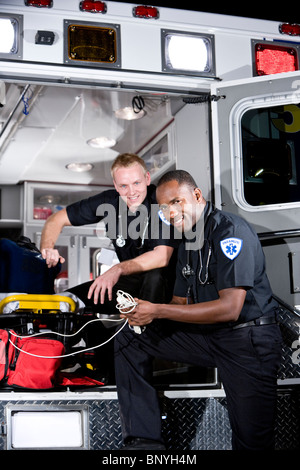 Multirazziale paramedici preparazione di attrezzature mediche in ambulanza Foto Stock