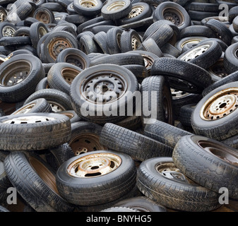 Sullo sfondo di un vecchio usurato pneumatici per auto su junkyard Foto Stock