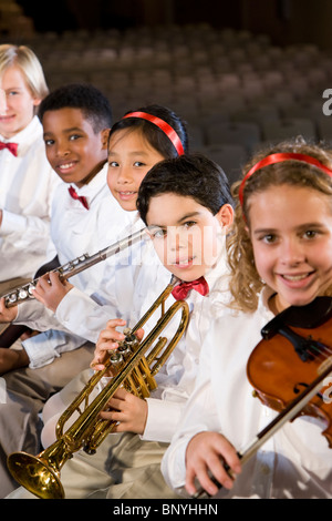 Giovani studenti suonare strumenti musicali in auditorium della scuola Foto Stock