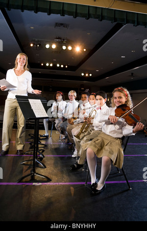 Giovani studenti suonare strumenti musicali in auditorium della scuola Foto Stock