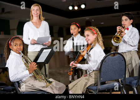 La scuola dei bambini suonare strumenti musicali in band con insegnante Foto Stock