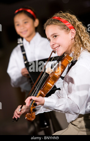 La scuola dei bambini suonare strumenti musicali, concentrarsi sulla ragazza con violino Foto Stock