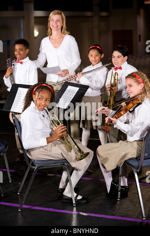 La scuola dei bambini suonare strumenti musicali in band con insegnante Foto Stock