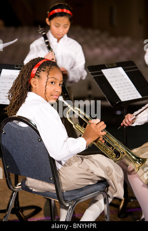 Bambini che giocano gli strumenti musicali a concentrarsi sulla ragazza con tromba Foto Stock