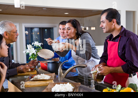 Madre ispanica che serve cena di famiglia in cucina Foto Stock