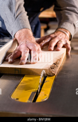 Senior uomo in macchine per la lavorazione del legno negozio utilizzando sega da tavolo Foto Stock