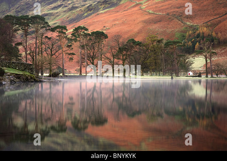 Buttermere Lago in autunno con Lakeland Fells riflessioni sulla calma piatta superficie, Lake District, Cumbria, Regno Unito Foto Stock