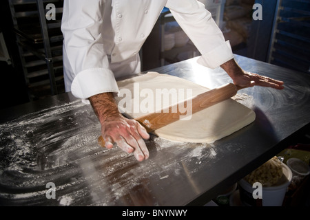 Pastry chef lavorare la pasta con il mattarello Foto Stock