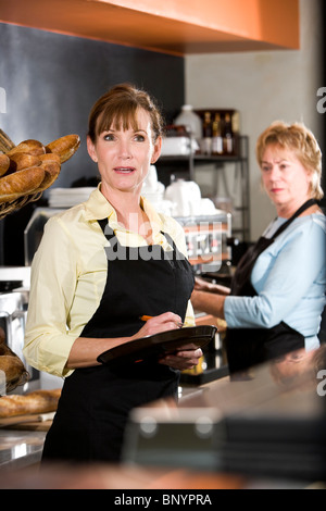 Cameriera in un coffee shop prendendo l'ordine del cliente Foto Stock