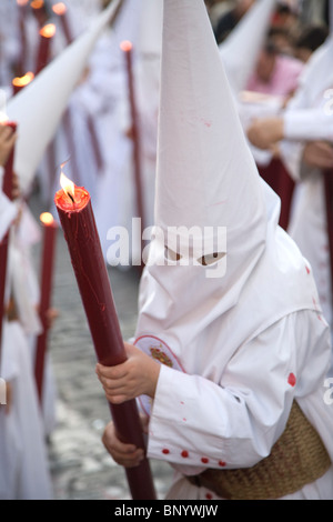 I credenti con candele in una processione per la domenica delle Palme, Sevilla, Spagna Foto Stock