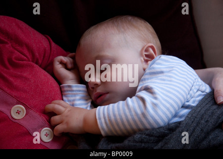 Baby boy (16 mesi) dormire sul suo petto delle madri. Foto Stock