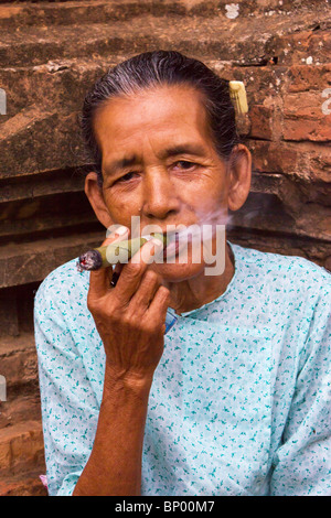 Vecchia donna fumatori cheroot a Bagan, Myanmar Foto Stock