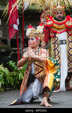 Ballerino femmina pleading lungo con un ballerino maschio in background durante il barong dance in Ubud, Bali. Foto Stock