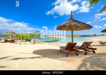 Scena di spiaggia con ombrelloni di paglia, Mauritius Foto Stock