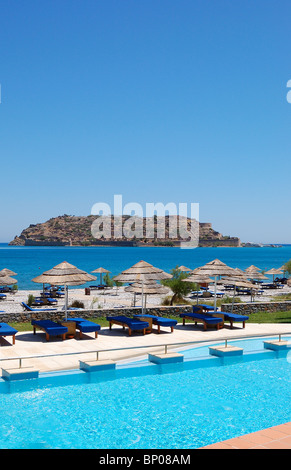 Spiaggia e piscina con vista sull'isola di Spinalonga, Creta, Grecia Foto Stock