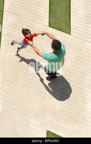 Padre figlio oscillanti intorno a Foto Stock
