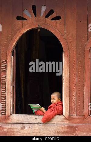 Giovane monaco buddista nella finestra di Shwe Yan Pyay monastero, vicino a Nyaung Shwe sul Lago Inle, MYANMAR Birmania Foto Stock