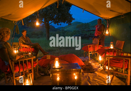 Kenya, Chyulu Hills, Ol Donyo Wuas. Un paio di gustare un drink nel disordine tenda su un safari di equitazione con Ride in Africa. (MR) Foto Stock