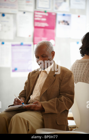 Anziani uomo nero in sala d'attesa Foto Stock