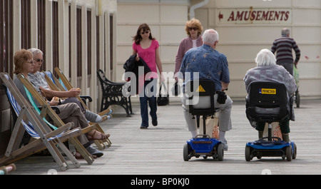 I pensionati su mobiity scooter su Eastbourne Pier. Foto di James Boardman Foto Stock