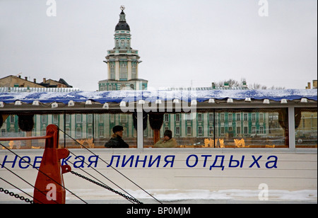 La Russia, San Pietroburgo; un ristorante-nave ancorata sul fiume Neva con il 'Kunstkamera' dietro. Foto Stock