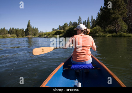 Una donna paddling una canoa sul fiume Deschutes, Oregon Foto Stock