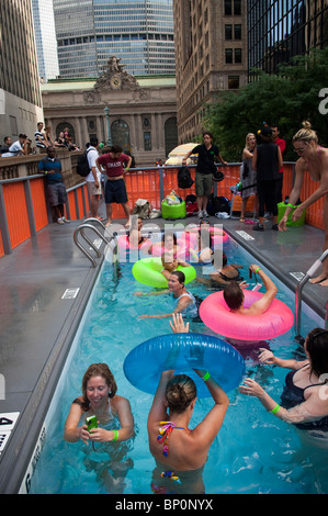 I Newyorkesi e visitatori di prendere vantaggio di cassonetti trasformato in aree urbane piscine su Park Avenue durante l estate strade Foto Stock