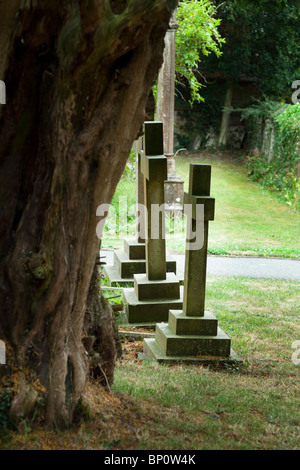 Vecchio, weathered Grave pietre e Yew Tree in un villaggio inglese chiesa Foto Stock