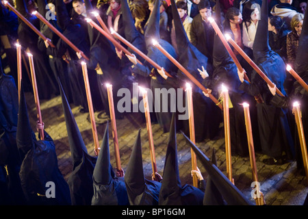 I credenti con candele durante la processione di Pasqua, Siviglia, Spagna Foto Stock